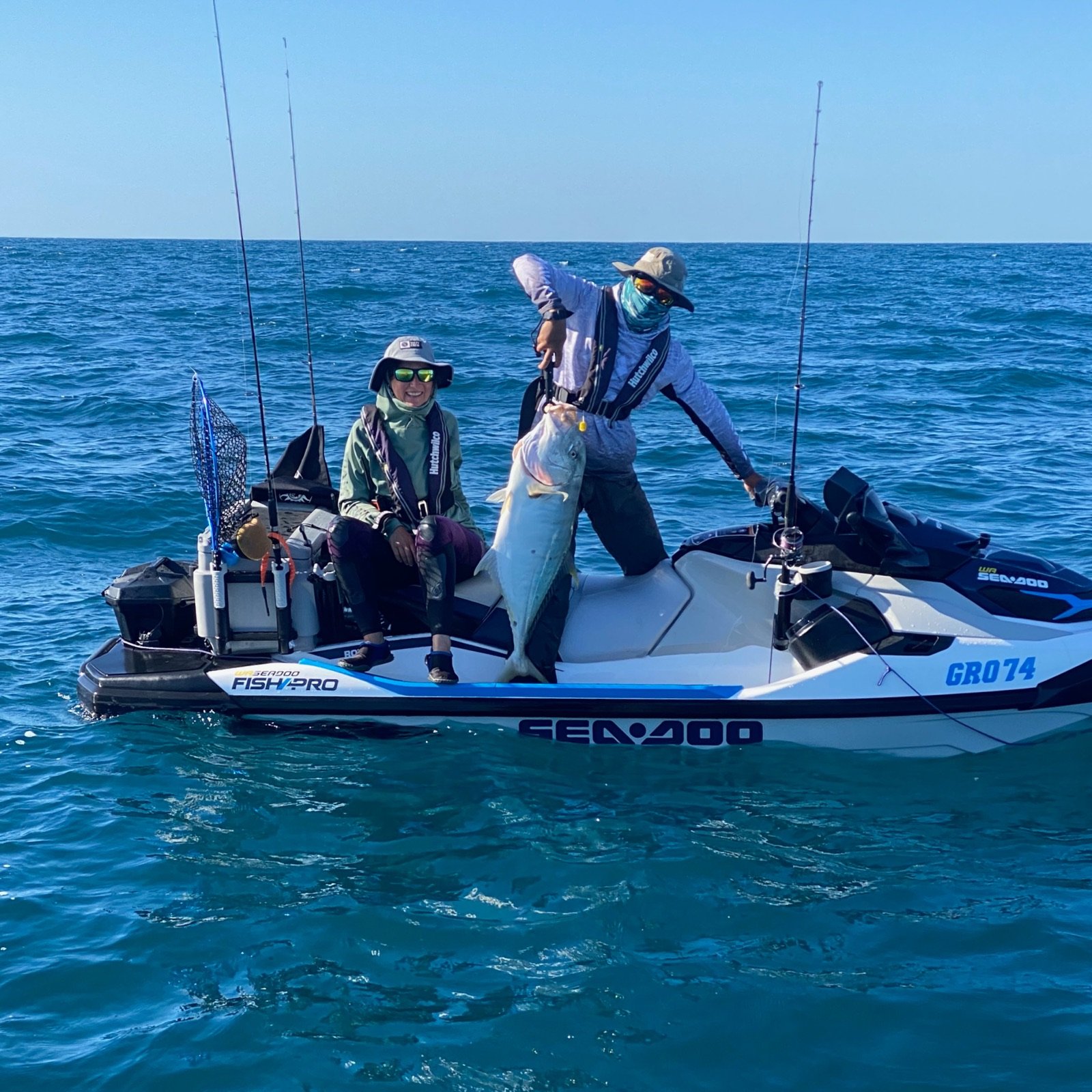 Two anglers on a Sea-Doo FishPro landing a large golden trevally